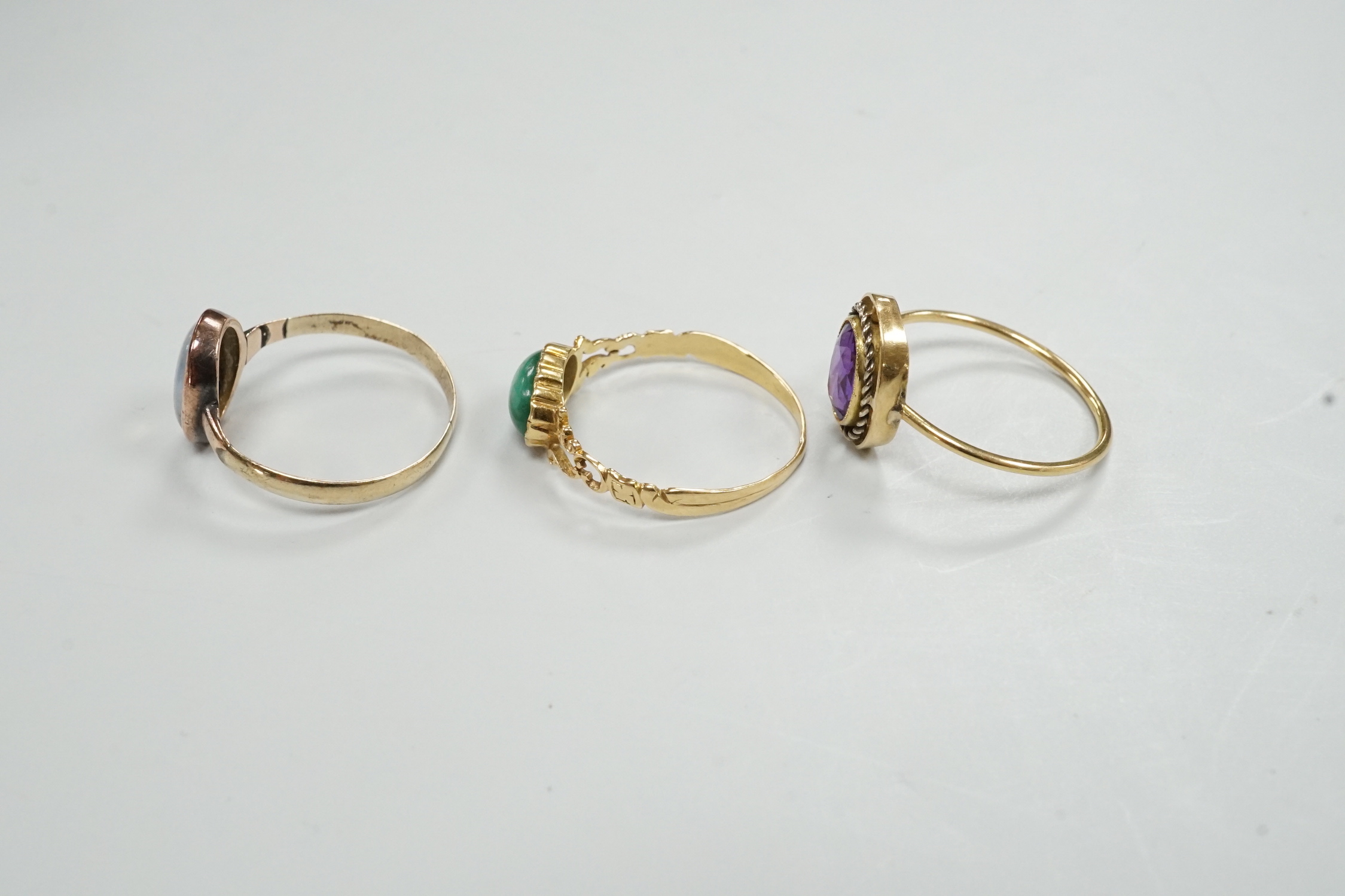 Three assorted yellow metal and gem set rings, gross weight 4.1 grams.